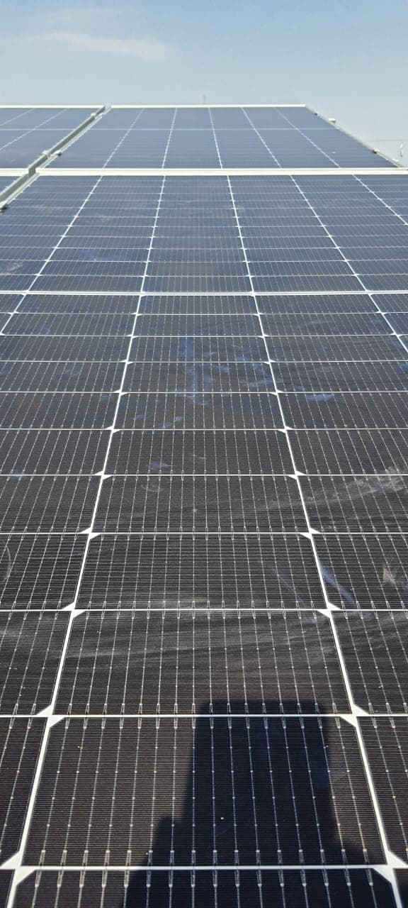 Rows of monocrystalline solar modules on a rooftop array in Indore under clear sky