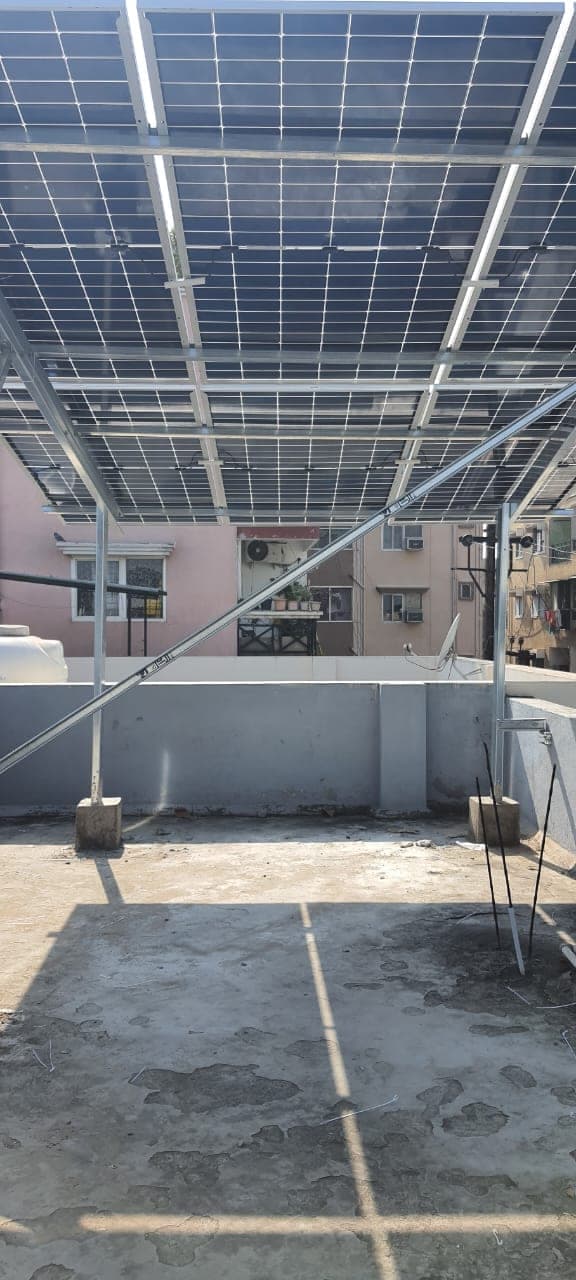 Shaded terrace floor under a raised solar panel array on an Indore house